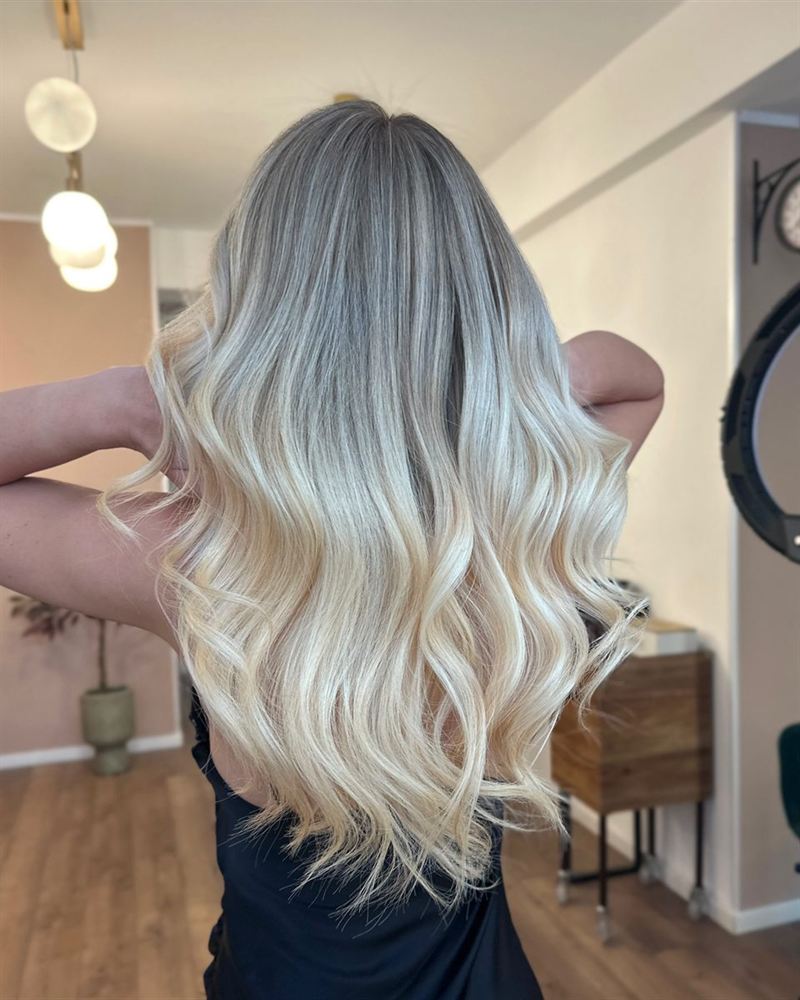 Detaliu: păr blond ridicat cu mâna, în fața oglinzii