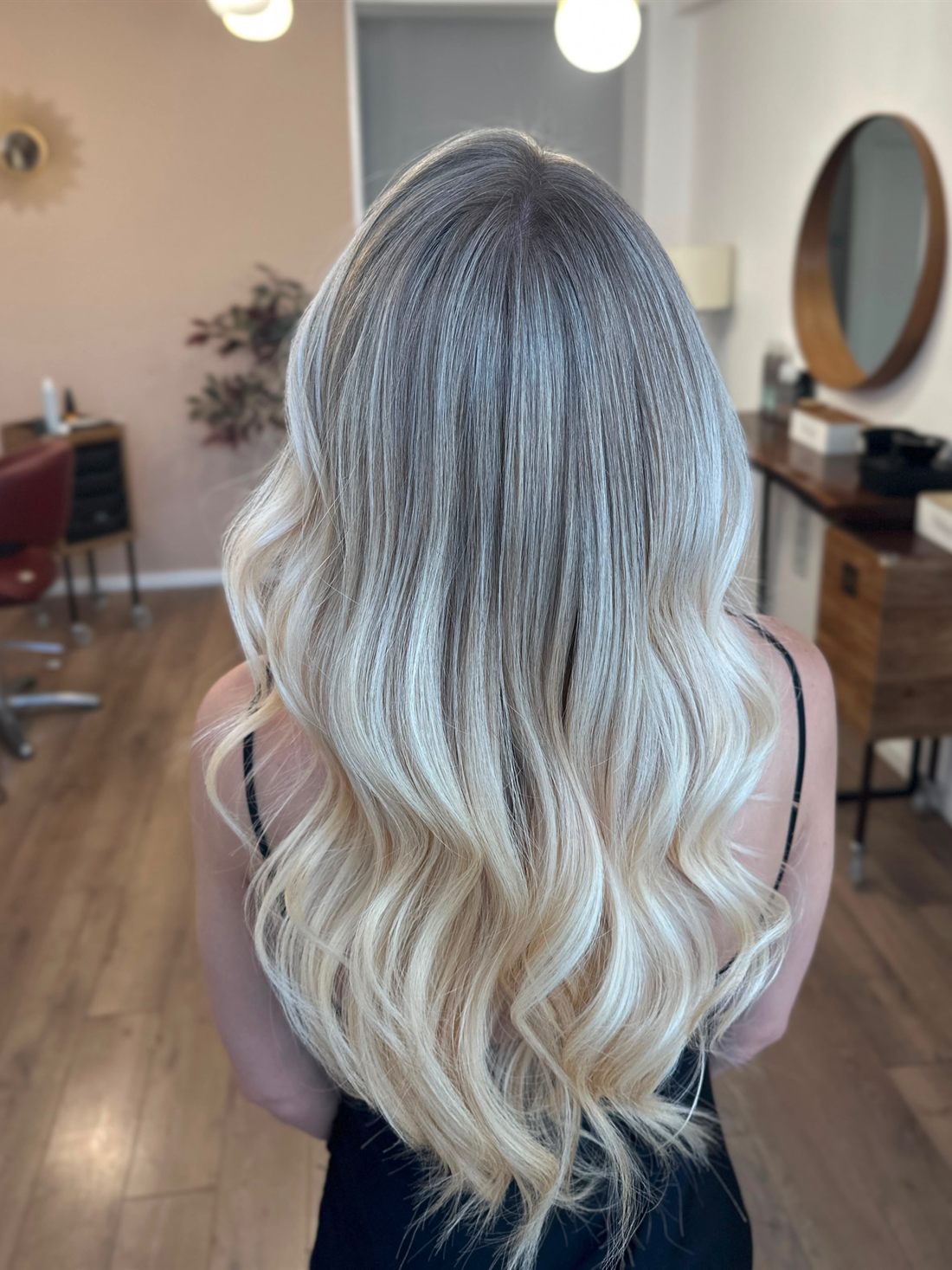 Balayage blond platinat, văzut din spate, în salon