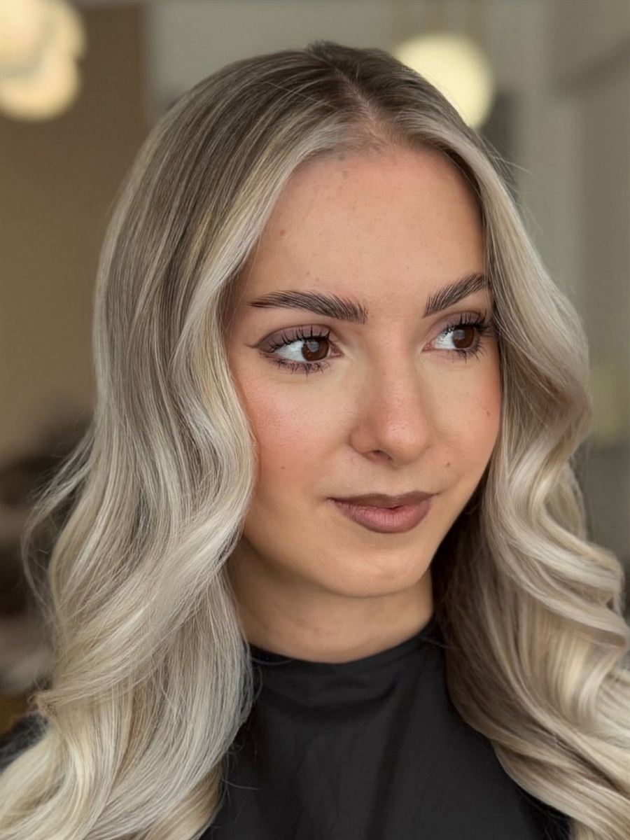 Clientă cu balayage blond, portret trei sferturi în salon